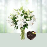 Send 10 White Lilies Flowers in glass vase with 1 kg heart shaped Chocolate Cake Gift Online in India